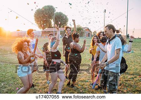 Group of friends dancing, playing with confetti in park View Large Photo Image Stock Photography - Group of friends dancing, playing with confetti in park. Fotosearch