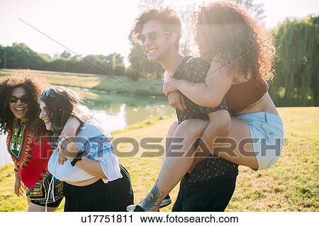 Stock Image - Group of friends having fun by lake. Fotosearch