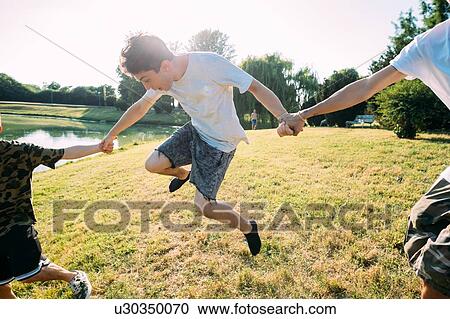 Stock Image - Group of friends having fun by lake. Fotosearch