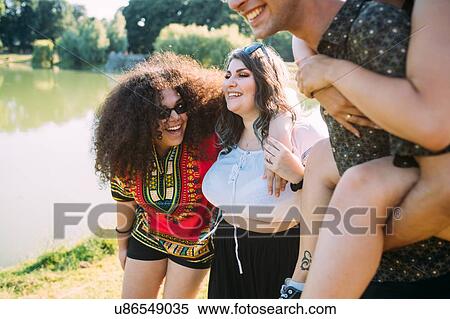 Stock Photography - Group of friends having fun by lake. Fotosearch