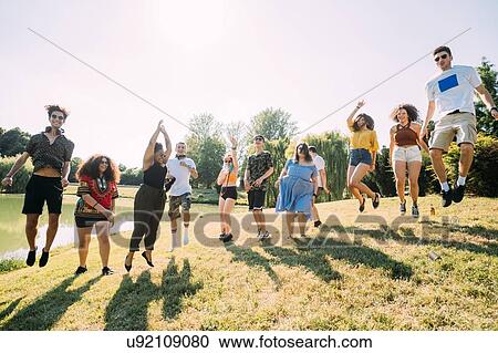 Group of friends jumping in park View Large Photo Image Stock Image - Group of friends jumping in park. Fotosearch