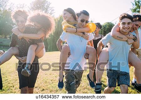 Group of friends piggyback racing in park View Large Photo Image Stock Photo - Group of friends piggyback racing in park. Fotosearch