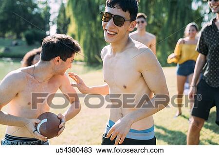Group of friends playing football in park View Large Photo Image Stock Image - Group of friends playing football in park. Fotosearch