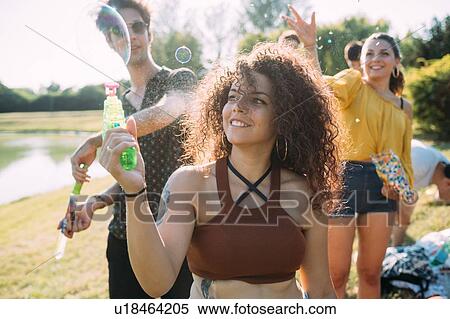 Group of friends playing with bubble gun in park View Large Photo Image Stock Photography - Group of friends playing with bubble gun in park. Fotosearch