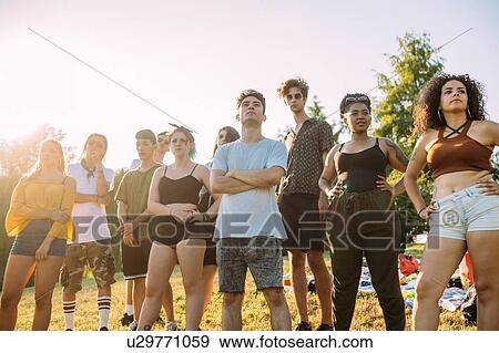 Stock Photo - Group of friends posing under hot sun in park. Fotosearch