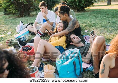 Group of friends relaxing at picnic in park View Large Photo Image Stock Photo - Group of friends relaxing at picnic in park. Fotosearch