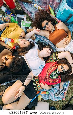 Stock Photo - Group of friends relaxing at picnic in park. Fotosearch