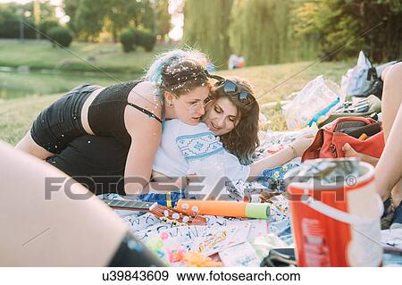 Stock Photo - Group of friends relaxing at picnic in park. Fotosearch