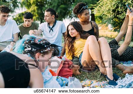 Group of friends relaxing at picnic in park View Large Photo Image Stock Photo - Group of friends relaxing at picnic in park. Fotosearch