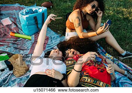 Group of friends relaxing at picnic in park View Large Photo Image Stock Photograph - Group of friends relaxing at picnic in park. Fotosearch