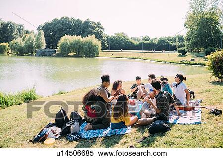 Group of friends relaxing at picnic in park View Large Photo Image Stock Photography - Group of friends relaxing at picnic in park. Fotosearch