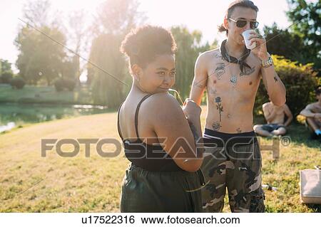 Stock Photograph - Group of friends relaxing by lake. Fotosearch