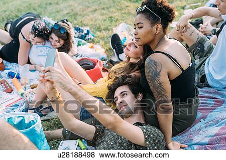 Group of friends relaxing, taking selfie at picnic in park View Large Photo Image Stock Photo - Group of friends relaxing, taking selfie at picnic in park. Fotosearch