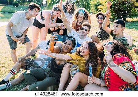 Group of friends taking selfie, playing with confetti in park View Large Photo Image Stock Image - Group of friends taking selfie, playing with confetti in park. Fotosearch