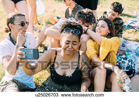 Group of friends taking selfie, playing with confetti in park View Large Photo Image Stock Image - Group of friends taking selfie, playing with confetti in park. Fotosearch