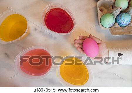 Stock Photography - Hand of girl holding pink Easter egg. Fotosearch