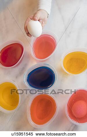 Stock Photography - Hand of girl selecting dye for Easter egg. Fotosearch