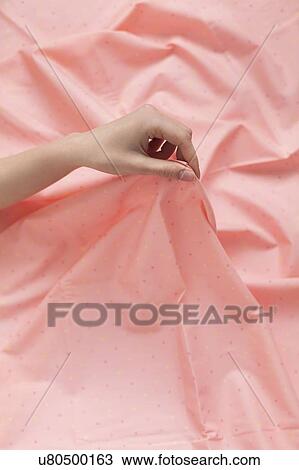 Hand of woman holding pink fabric View Large Photo Image Stock Image - Hand of woman holding pink fabric. Fotosearch