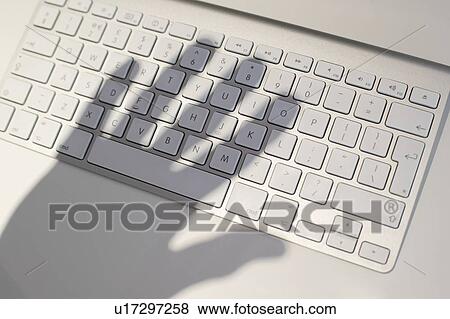 Hand shadow casted over keywboard, conceptual image of cyber crime. View Large Photo Image Stock Photo - Hand shadow casted over keywboard, conceptual image of cyber crime.. Fotosearch