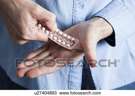 Stock Image - Hands holding hormone replacement therapy (HRT) pills. HRT pills are synthetic hormones used to treat menopausal women. They counteract the hormone deficiency that occurs at menopause.. Fotosearch