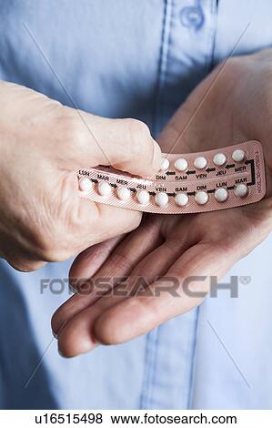 Stock Photo - Hands holding hormone replacement therapy (HRT) pills. HRT pills are synthetic hormones used to treat menopausal women. They counteract the hormone deficiency that occurs at menopause.. Fotosearch