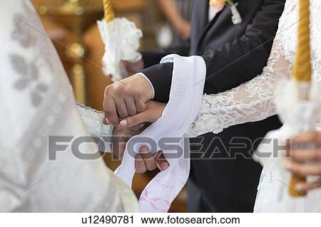 Hands of bride and groom tied together during wedding ceremony View Large Photo Image Stock Image - Hands of bride and groom tied together during wedding ceremony. Fotosearch
