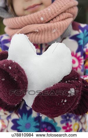 Picture - Hands of girl holding snow heart. Fotosearch