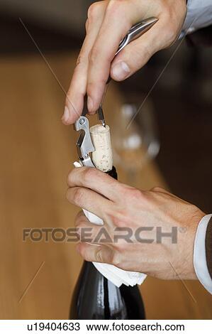 Hands of man opening bottle of wine View Large Photo Image Stock Image - Hands of man opening bottle of wine. Fotosearch
