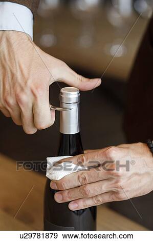 Hands of man opening bottle of wine View Large Photo Image Stock Photo - Hands of man opening bottle of wine. Fotosearch
