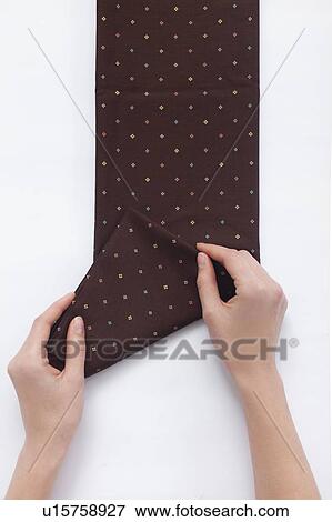Stock Photo - Hands of woman folding brown fabric. Fotosearch
