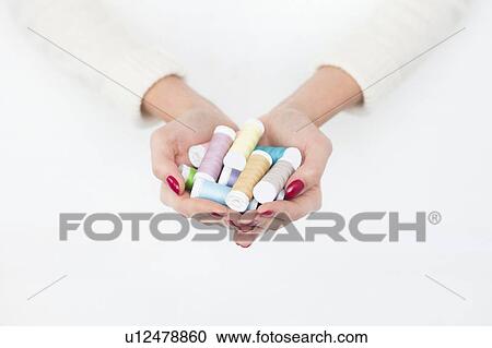 Hands of woman holding spools of cotton View Large Photo Image Stock Image - Hands of woman holding spools of cotton. Fotosearch