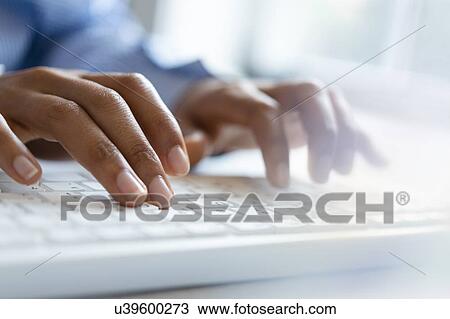 Stock Image - Hands of young woman typing on computer keyboard. Fotosearch
