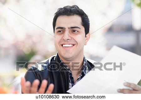 Happy young man holding piece of paper View Large Photo Image Stock Image - Happy young man holding piece of paper. Fotosearch