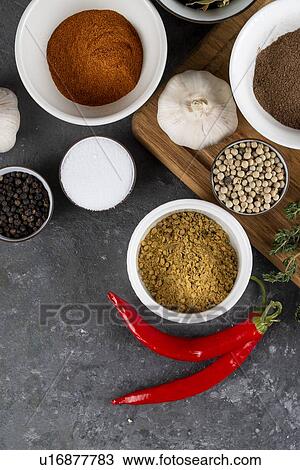Stock Image - Herbs and spices with chili peppers. Fotosearch