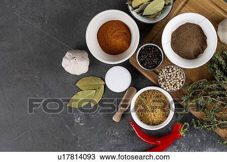 Stock Image - Herbs and spices with chili peppers. Fotosearch