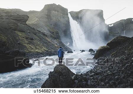 Stock Photography - Hiker by Haifoss waterfall in Iceland. Fotosearch