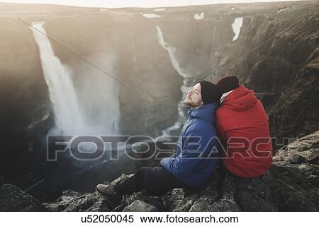 Hiker couple sitting on cliff by Haifoss waterfall in Iceland View Large Photo Image Stock Photography - Hiker couple sitting on cliff by Haifoss waterfall in Iceland. Fotosearch