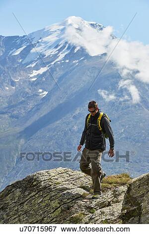 Stock Photo - Hiker enjoying walk, Saas-Fee, Valais, Switzerland. Fotosearch