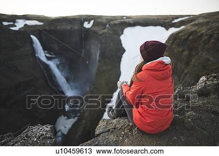 Hiker sitting on cliff by Haifoss waterfall in Iceland View Large Photo Image Stock Image - Hiker sitting on cliff by Haifoss waterfall in Iceland. Fotosearch