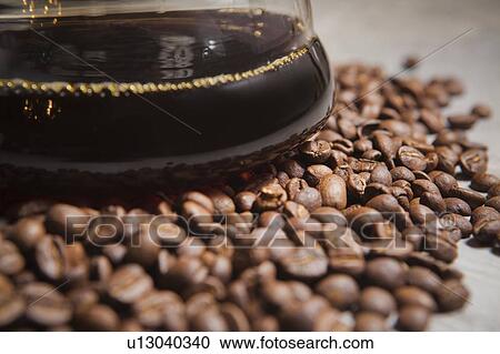 Jug of coffee on roasted coffee beans View Large Photo Image Stock Image - Jug of coffee on roasted coffee beans. Fotosearch
