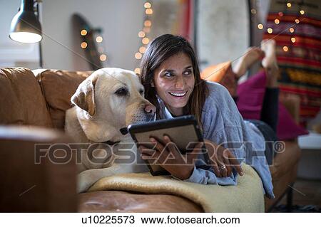 Labrador retriever and young woman lying on living room sofa looking sideways View Large Photo Image Stock Image - Labrador retriever and young woman lying on living room sofa looking sideways. Fotosearch