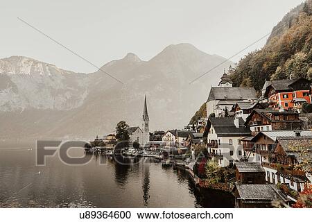 Stock Image - Lakeside village and misty mountains, elevated view, Hallstatt, Upper Austria. Fotosearch