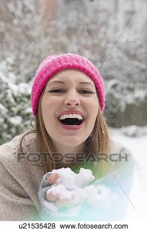Laughing young woman holding snow View Large Photo Image Stock Photo - Laughing young woman holding snow. Fotosearch