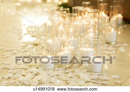 Stock Photo - Lit white candles and petals. Fotosearch