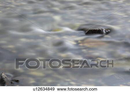 Long exposure shot of rocks in river View Large Photo Image Stock Photo - Long exposure shot of rocks in river. Fotosearch
