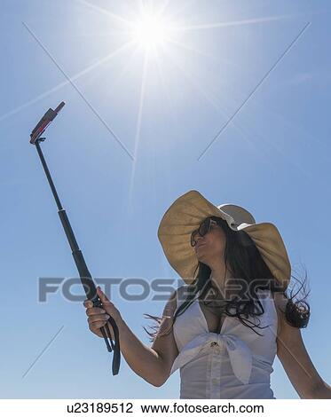 Low Angle Shot Of Woman Using Selfie Stick Stock Image U23189512