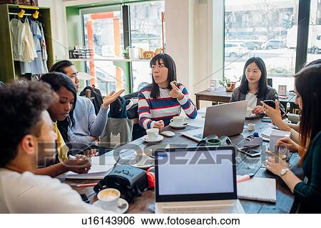 Male and female business team meeting while having working lunch at cafe table View Large Photo Image Stock Photograph - Male and female business team meeting while having working lunch at cafe table. Fotosearch
