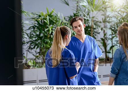 Male and female junior doctors chatting outside hospital View Large Photo Image Stock Image - Male and female junior doctors chatting outside hospital. Fotosearch
