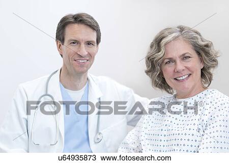 Male doctor and female patient smiling towards camera. View Large Photo Image Stock Image - Male doctor and female patient smiling towards camera.. Fotosearch