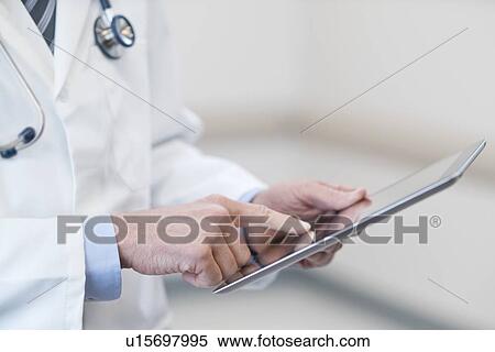 Stock Photography - Male doctor using digital tablet.. Fotosearch